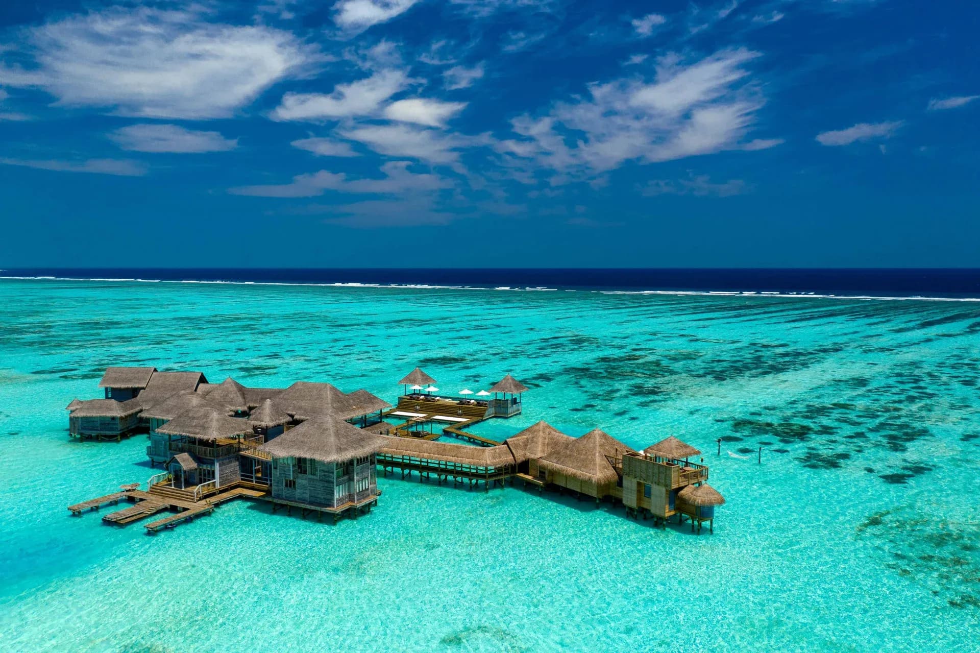 maldives when to visit, Maldives, an aerial of an over-water reserve across a calm, clear dry-season lagoon