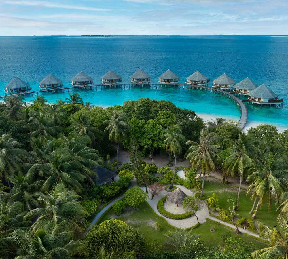 Adaaran Meedhupparu, oblique aerial onto Prestige Water Villa crescent with jetty curving from island interior, Raa Atoll, Maldives