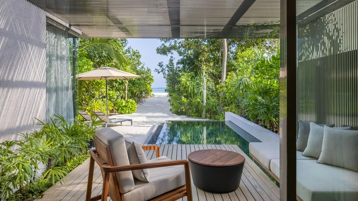 Alila Kothaifaru Maldives, Sunrise Beach Villa with covered teak terrace, rattan armchair, plunge pool and parasol with beach beyond, Raa Atoll, Maldives