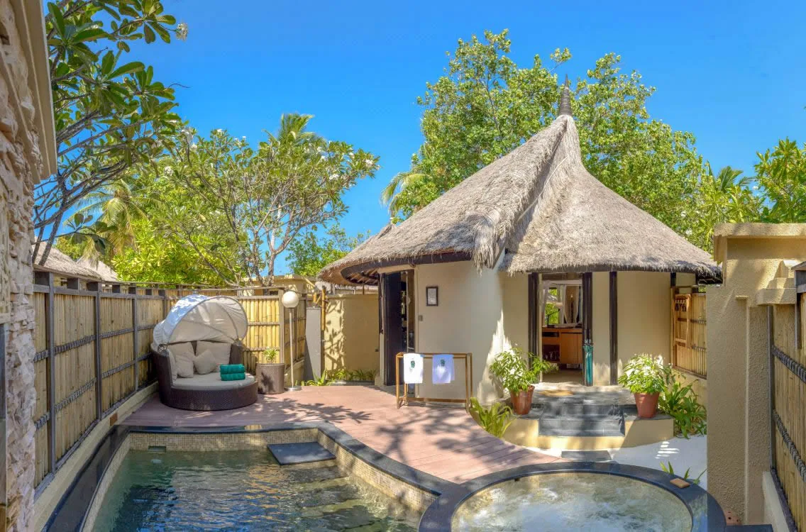 Banyan Tree Vabbinfaru, villa beach, North Malé Atoll, Maldives, Beachfront Pool Villa courtyard plunge pool, rectangular pool plus circular jacuzzi, thatched conical pavilion with covered dining and a tub, bamboo-screen privacy walls, woven covered daybed in the corner.