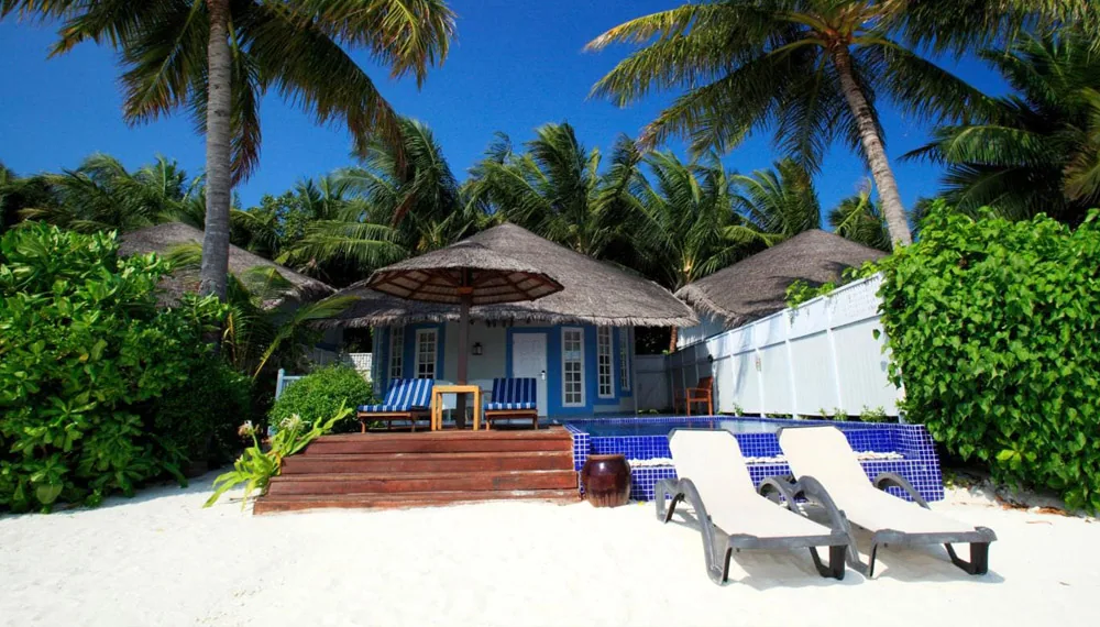 Centara Grand Island Resort & Spa Maldives, villa beach, Alif Dhaal (South Ari) Atoll, Maldives, Beachfront Pool Villa with twin thatched-roof beach umbrellas in front, a small blue-mosaic plunge pool beside the deck, two sun-loungers on the white sand under the palm canopy, the lagoon at the foreground.