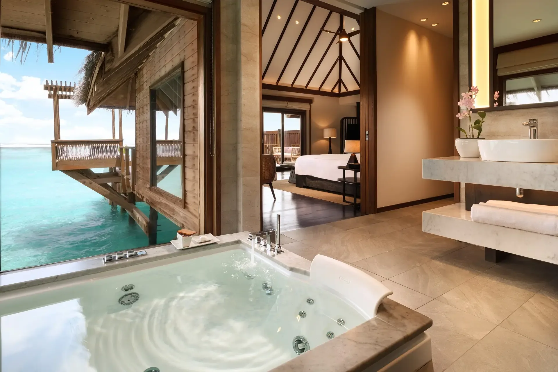Conrad Maldives Rangali Island, villa overwater, Alif Dhaal (South Ari) Atoll, Maldives, Premier Water Villa with Pool interior, marble vessel jacuzzi with retractable wall to the overwater deck, open-plan layout to the bedroom under the pitched timber ceiling.