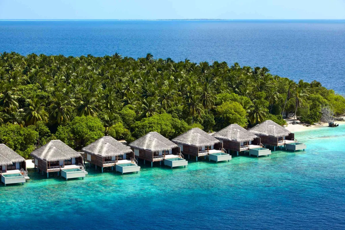 Dusit Thani Maldives, aerial, Baa Atoll, Maldives, Dusit Thani Maldives, Mudhdhoo island geometry in northern Baa Atoll UNESCO Biosphere Reserve with the over-water jetty cluster and the Devarana Spa wellness pavilion configuration.