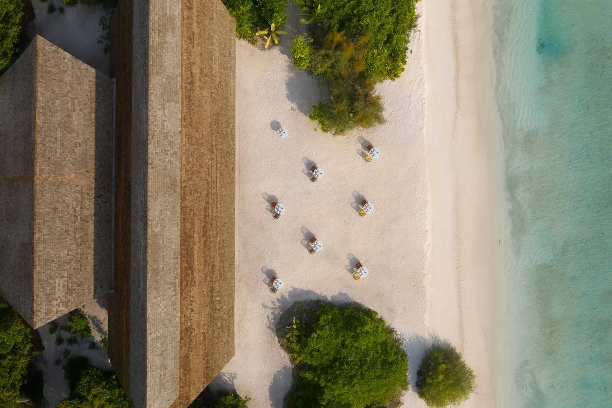 Emerald Faarufushi, Aqua beachside dining top-down aerial with thatched parasol-shaded tables on white sand next to main thatched-roof restaurant, Raa Atoll, Maldives