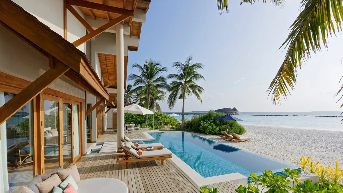 Emerald Faarufushi, Presidential Beach Villa exterior two-storey villa with covered porch, infinity pool extending to beach, sun loungers and palm canopy, Raa Atoll, Maldives