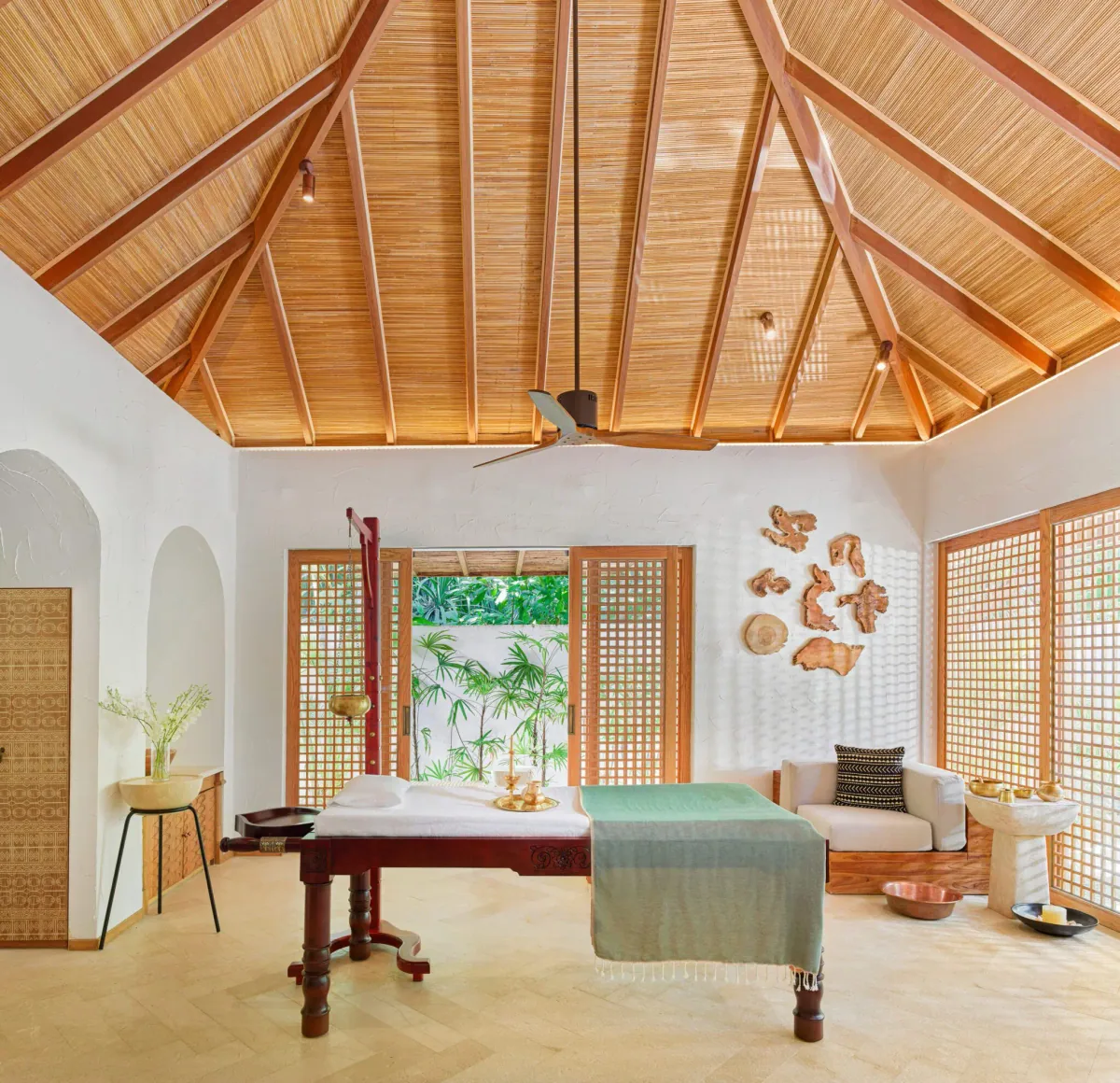 Sirru Fen Fushi Private Lagoon Resort, Willow Stream Spa Ayurveda treatment pavilion with dark-wood shirodhara-style table, latticed bamboo screens and palm-thatched cathedral ceiling, Shaviyani Atoll, Maldives