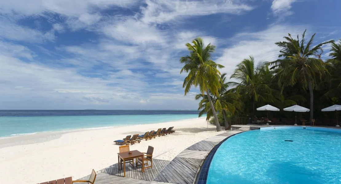 Filitheyo Island Resort, villa beach, Faafu Atoll, Maldives, Deluxe Beach Villa at the perimeter configuration with beach-edge infinity pool deck, sun loungers, and palm-back vegetation.
