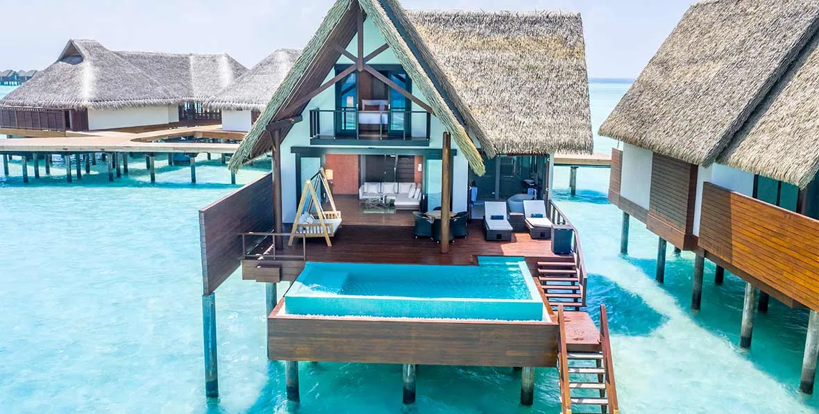 Heritance Aarah Maldives, villa overwater, Raa Atoll, Maldives, Heritance Ocean Pool Villa, 160 sqm two-story A-frame thatched-roof structure with cantilevered green-tile plunge pool projecting over the Aarah lagoon and ladder dropping into clear water.