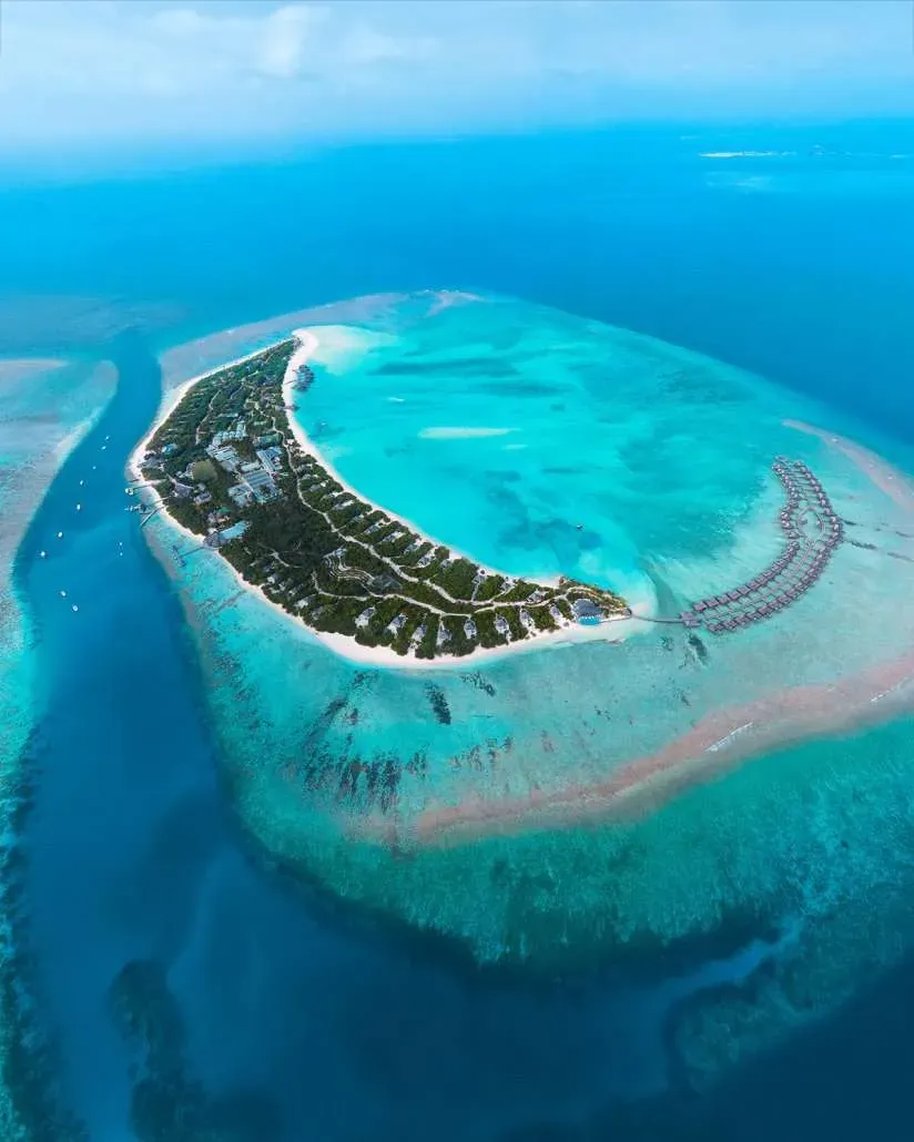Hideaway Beach Resort & Spa, aerial of Dhonakulhi crescent island with overwater villa arc, Haa Alif Atoll, Maldives