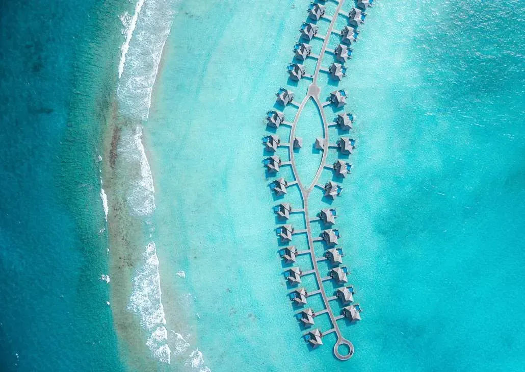 Hideaway Beach Resort & Spa, overwater villa cluster on stilts over Dhonakulhi lagoon eye-shape walkway, Haa Alif Atoll, Maldives