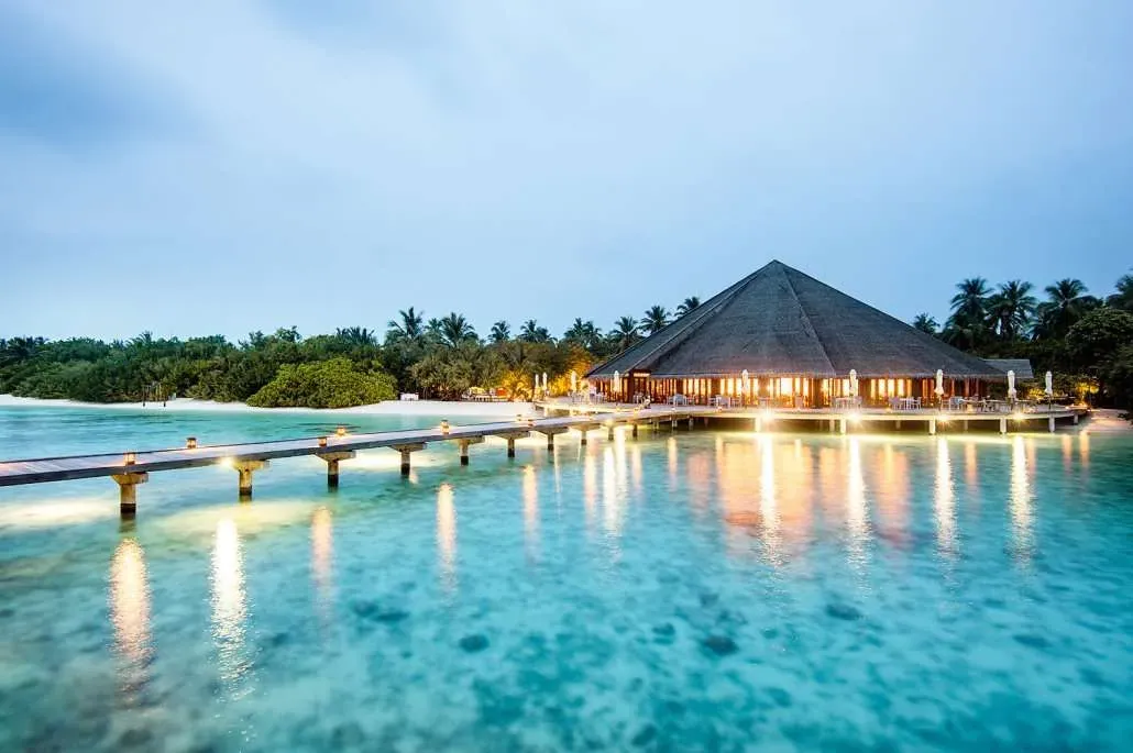Hideaway Beach Resort & Spa, Matheefaru beachfront pavilion at dusk over water at end of lit jetty, Haa Alif Atoll, Maldives