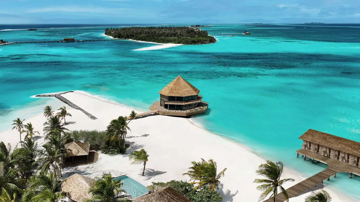 Innahura Maldives Resort, aerial, Lhaviyani Atoll, Maldives, Nala Maldives by Jawakara (formerly Innahura Maldives Resort) drone aerial showing the Olhu Bar over-water pavilion on a sand-spit, beach pool villas in the foreground, and the neighbouring Lhaviyani island in the background  ,   Crown & Champa's five-star adults-only configuration post-2025 reopening.