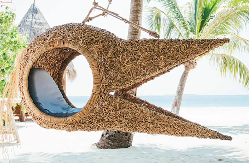 JOALI Maldives, art, Raa Atoll, Maldives, Manta Ray Fish Chair by Porky Hefer: a sculptural woven-fibre fish-form hanging seat suspended from a coconut palm on the beach, part of the JOALI commissioned art programme.