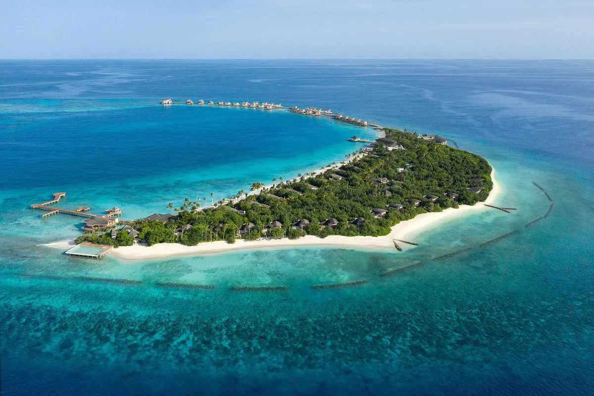 JW Marriott Maldives Resort & Spa, aerial of Vagaru island with overwater villas extending into Shaviyani western reef lagoon, Maldives