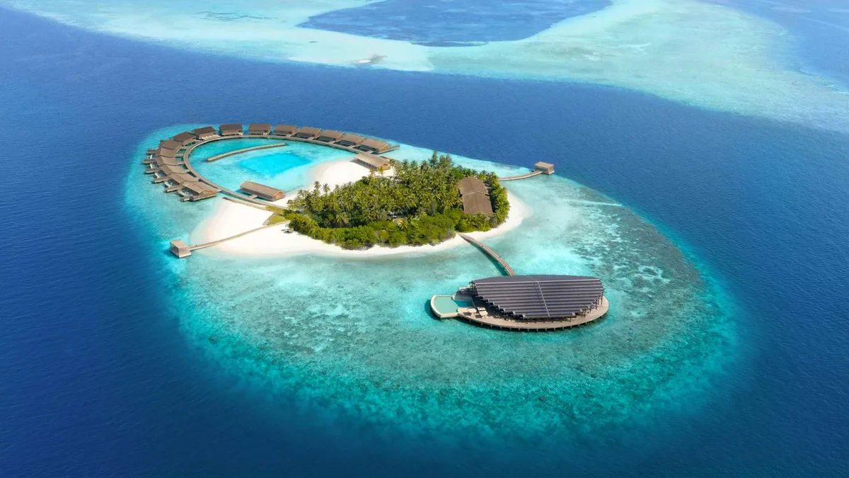 Kudadoo Maldives Private Island, aerial, Lhaviyani Atoll, Maldives, Kudadoo Maldives Private Island, the small natural-island geometry in central Lhaviyani Atoll with the over-water-only residence inventory and the roof-mounted solar array configuration.