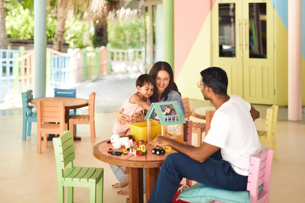 LUX* South Ari Atoll, activities, Alif Dhaal (South Ari) Atoll, Maldives, PLAY Kids' Club pavilion interior with the pastel rainbow-block double doors and the multi-colour child chair set, the LUX* brand-portfolio Kids' Club signature.