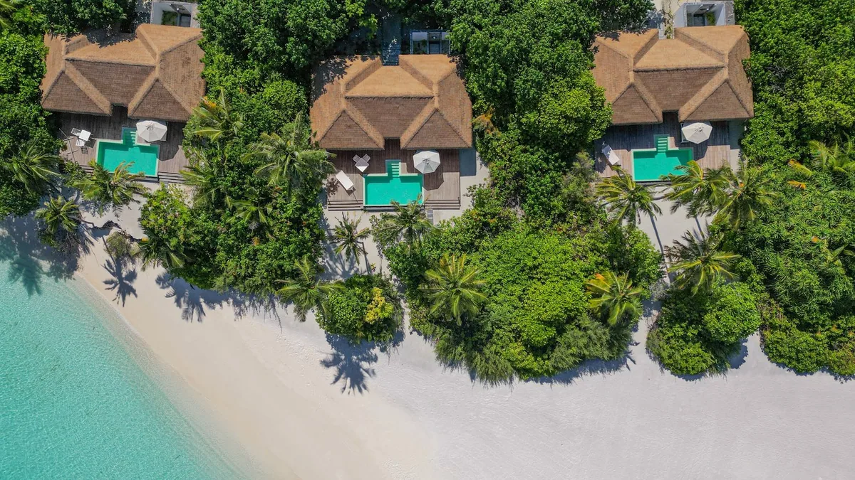 Noku Maldives, beach pool villa row top-down with green-tile pools and palm canopy, Noonu Atoll, Maldives