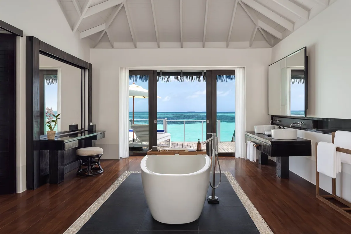 Noku Maldives, Overwater Villa bathroom with freestanding tub opening onto deck and ocean, Noonu Atoll, Maldives