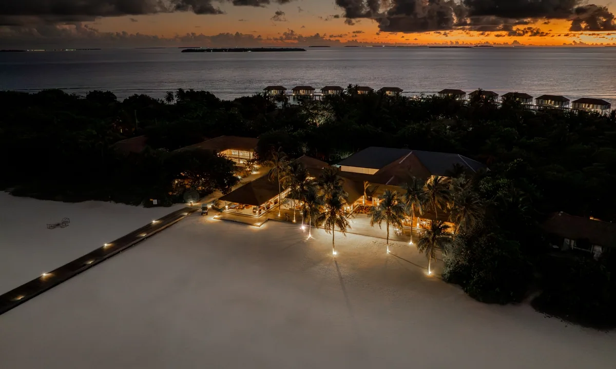 Noku Maldives, Palms restaurant at dusk on beach with OWV cluster visible behind, Noonu Atoll, Maldives