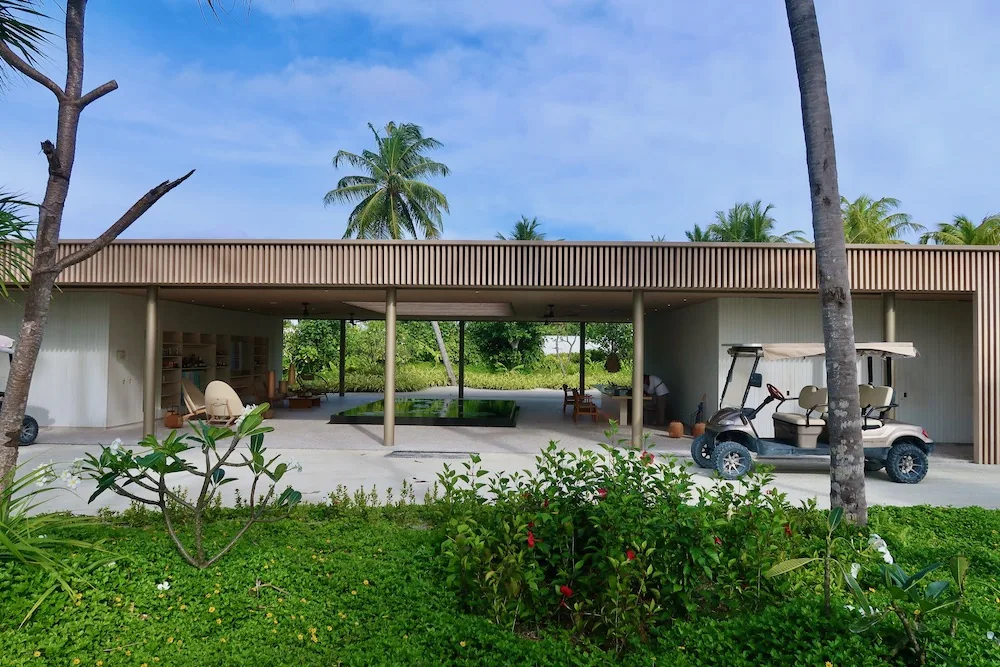 Patina Maldives, Fari Islands, spa, North Malé Atoll, Maldives, FLOW wellness pavilion exterior, the long reeded-timber-slat structure with open-air entry under the cantilevered roof, the building that houses the deprivation tank, Watsu pool, Hammam and treatment suites.