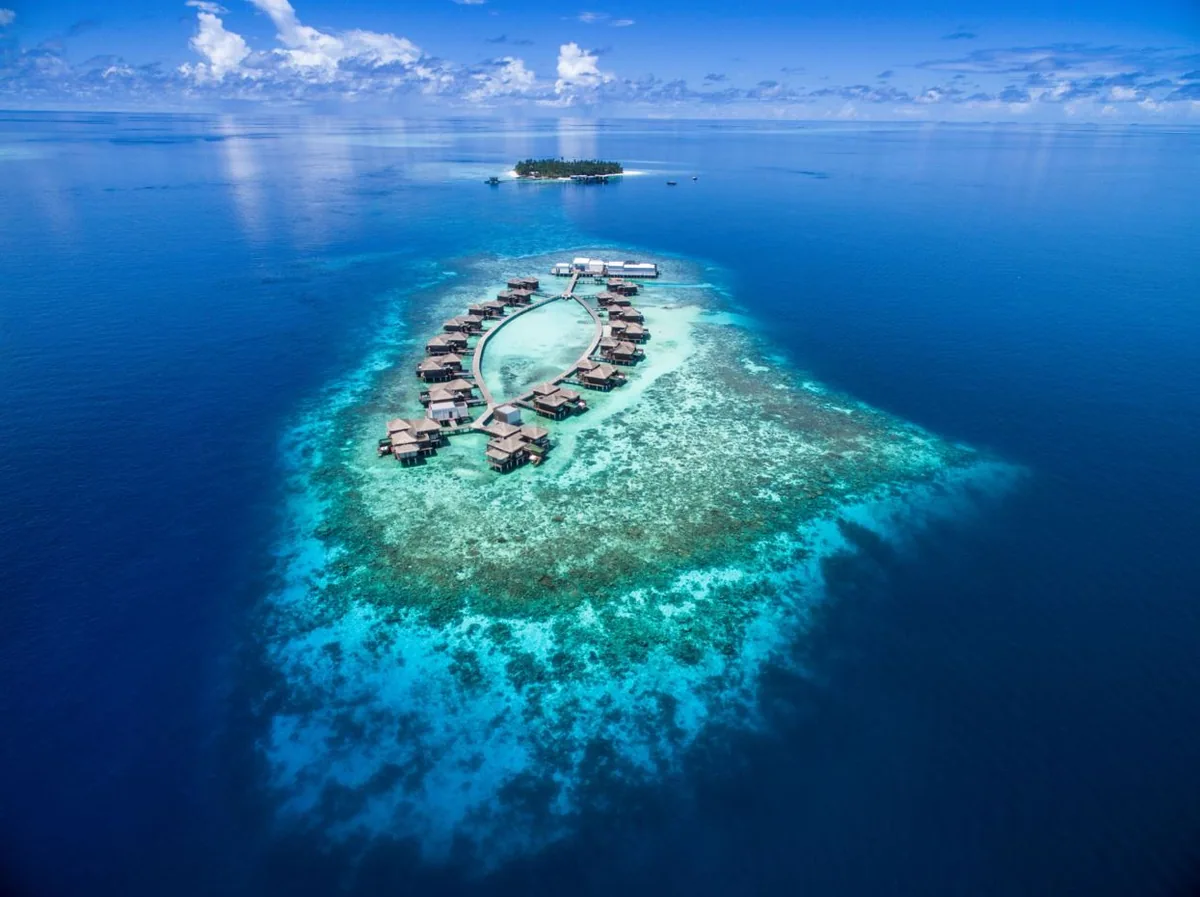 Raffles Maldives Meradhoo, aerial, Gaafu Alifu Atoll, Maldives, Raffles Maldives Meradhoo, the Meradhoo island geometry in Gaafu Alifu Atoll with the two-cluster villa configuration: beach-villa cluster along the perimeter + over-water-villa cluster on the lagoon side.