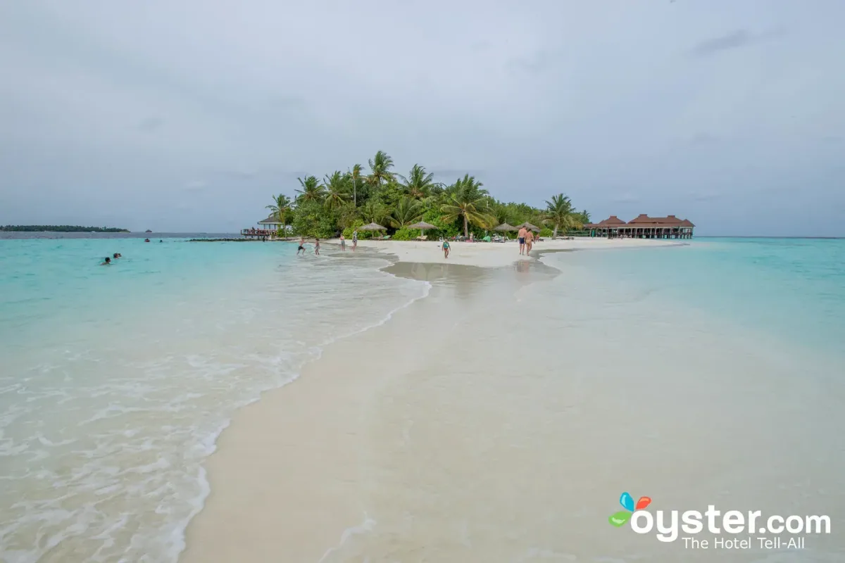 Ranveli Village, setting, Alif Dhaal (South Ari) Atoll, Maldives, Sandbar approach to Villingilivaru island at low tide with the sand-shoal extending into the shallow turquoise water, the over-water restaurant red roof at the right end, and the palm-covered eastern perimeter in the background.