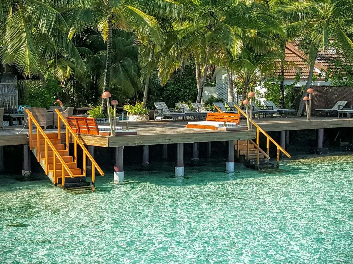 Ranveli Village, activities, Alif Dhaal (South Ari) Atoll, Maldives, Shore-snorkel access from the sundeck with the bright-orange timber staircases descending from the deck into the turquoise lagoon at the property's reef-edge water-entry point.