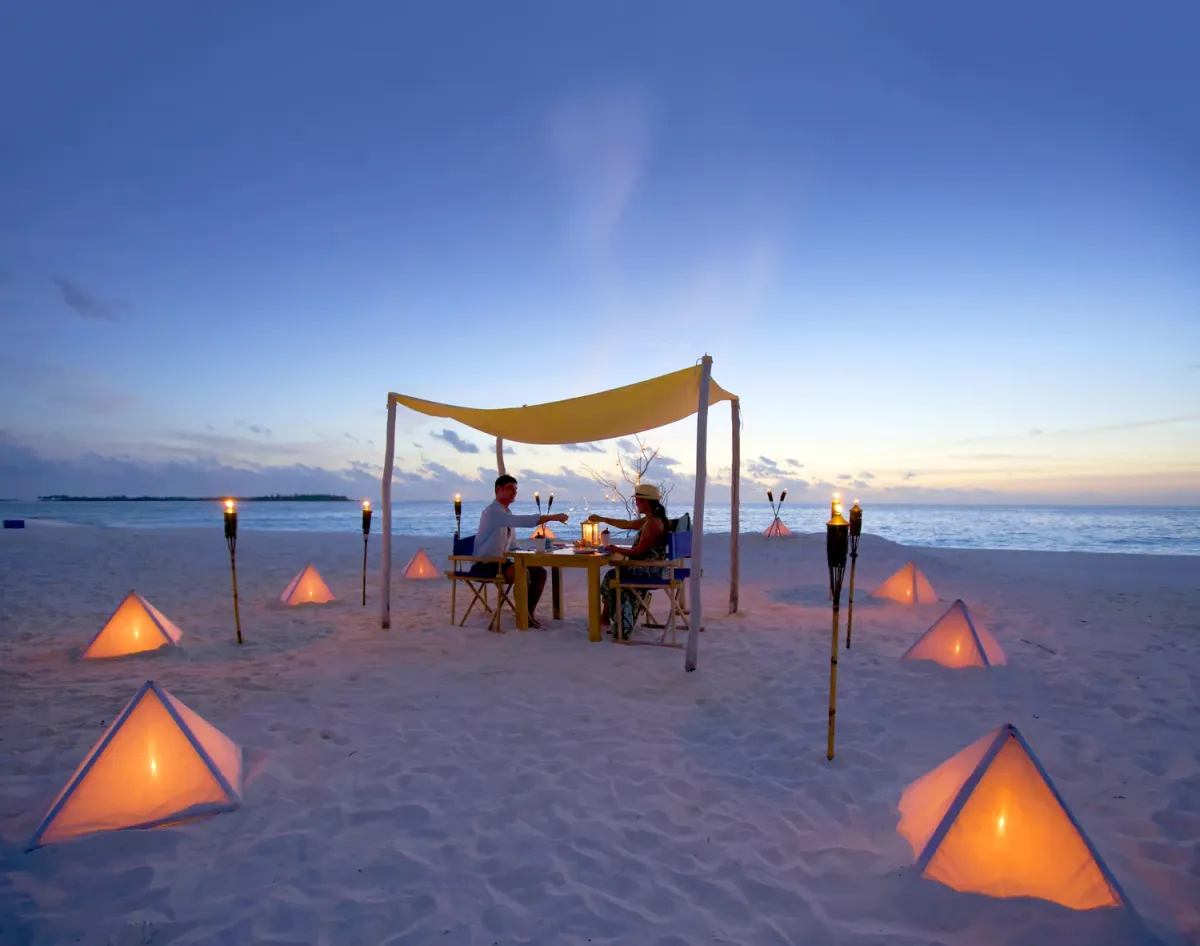 Sandbank dinner table set on an open sandbar with the ocean behind, Six Senses Laamu signature experience.