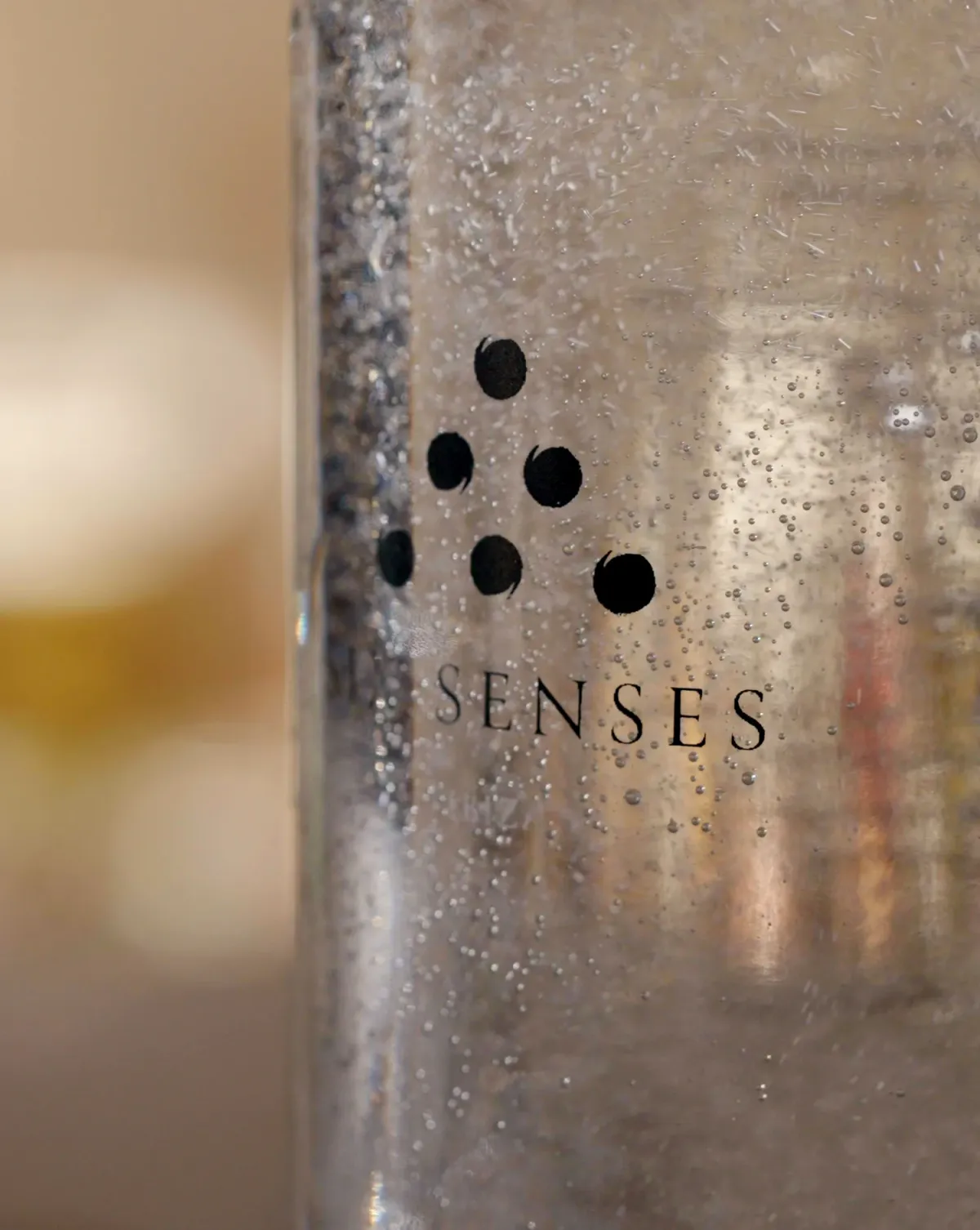 On-island glass bottling station at the Six Senses Laamu Earth Lab, refillable water bottles in a wooden rack.