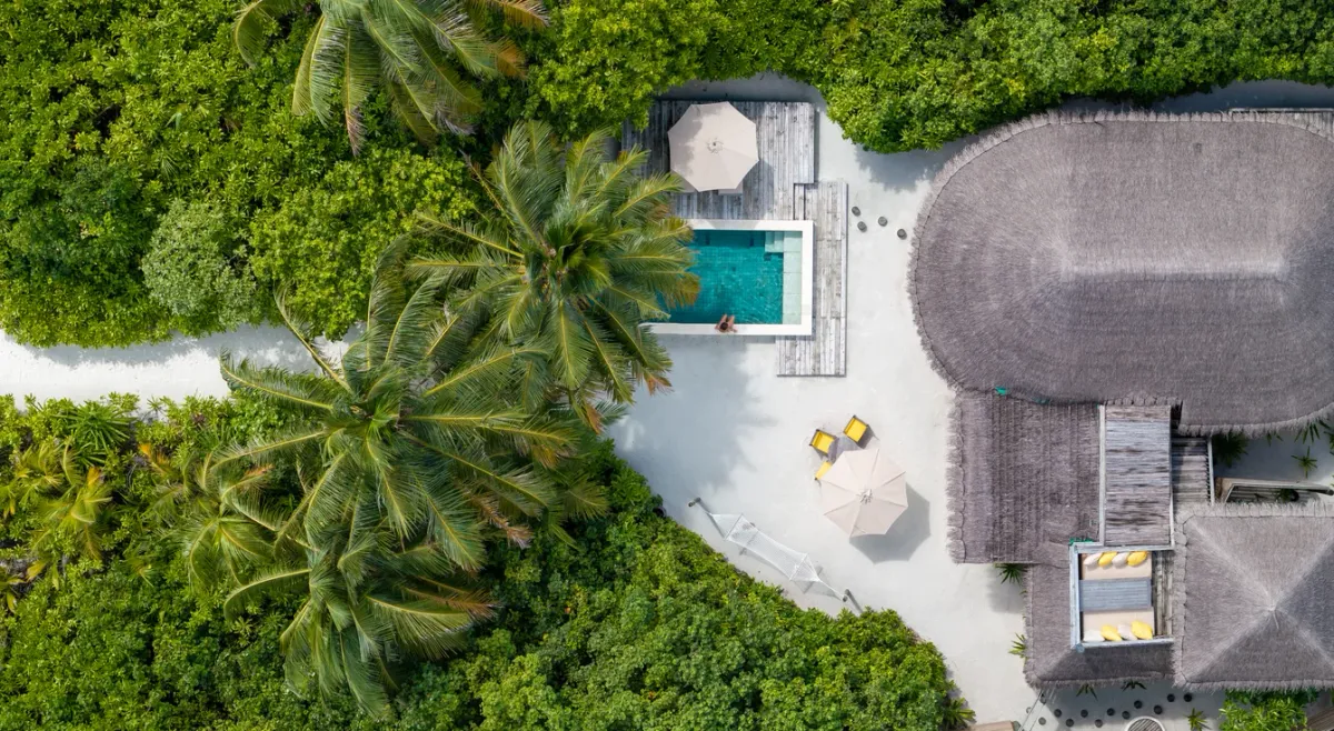 Family Beach Villa with private pool seen from above against jungle and lagoon edge at Six Senses Laamu.