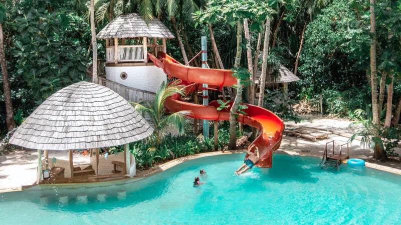 The Den kids club pool with a red water slide at Soneva Fushi.