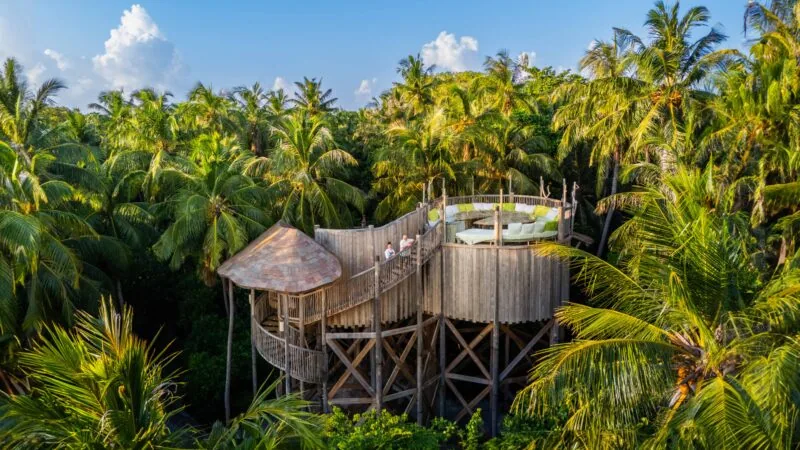 Flying Sauces treehouse dining pavilion at ground level, spiral staircase rising into the jungle canopy at Soneva Fushi.
