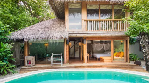 Villa 66 two-storey wooden Soneva Fushi Suite with private pool, set back from the beach behind a screen of palms.
