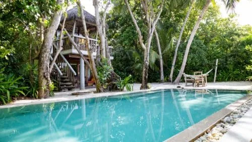 Crusoe with pool, treehouse-styled timber upper level and shaded outdoor seating in jungle setting at Soneva Fushi.
