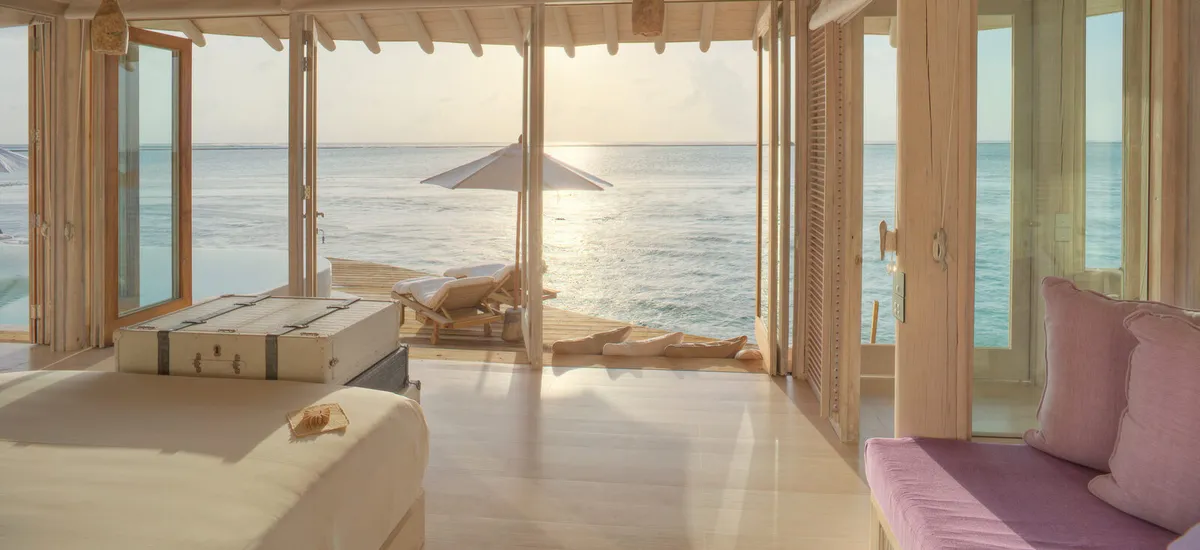 Two-bedroom Water Retreat villa with curving wooden slide from deck to lagoon at Soneva Jani.