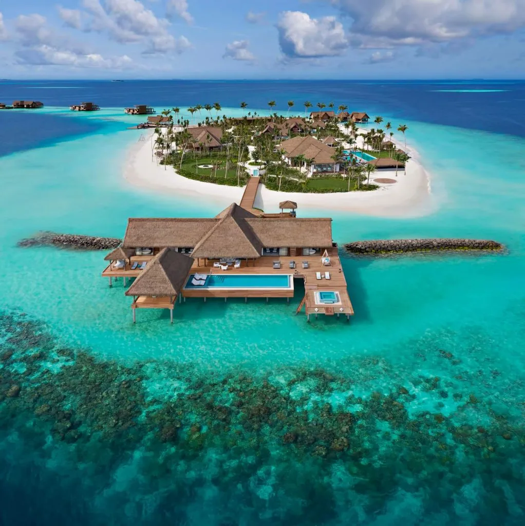 Waldorf Astoria Maldives Ithaafushi, setting, South Malé Atoll, Maldives, Ithaafushi-The Private Island residence, 32,000 sqm largest single-rental private island in the country, aerial view of the lead overwater pavilion and the lush vegetated estate behind.